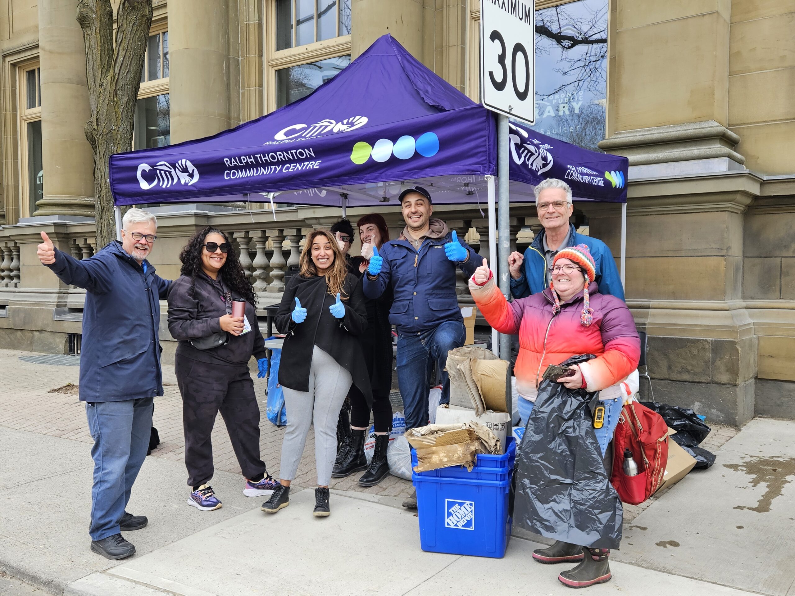 RTCC Staff pose under a purple tent as part of the Riverside and Queen St. East Community Cleanup.